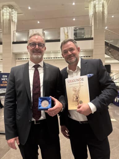 Ramon Thomas und NielsPfaff halten die Urkunde und die Ehrenplakette des Großen Preis des Mittelstands